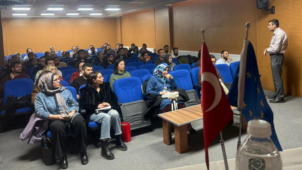 [Fotoğraf: Toplantı salonunda sunum yapan uzmanlar ve dinleyen öğretmenler]