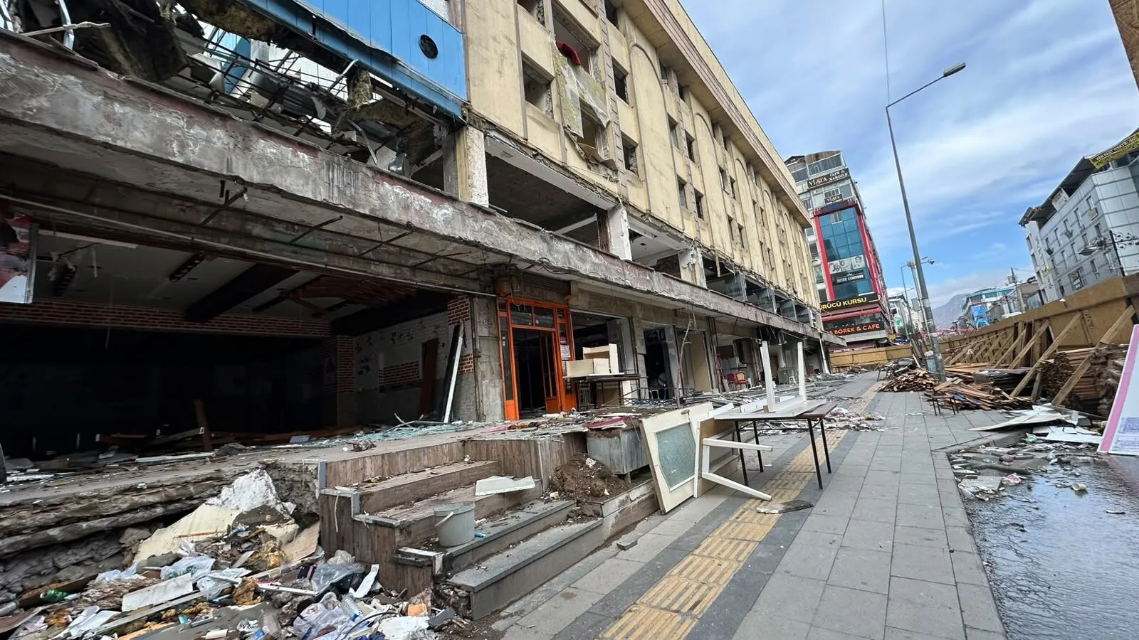 [Fotoğraf: Maraş Caddesi üzerinde etrafı güvenlik panelleriyle kapatılmış Akdamar Oteli binası]